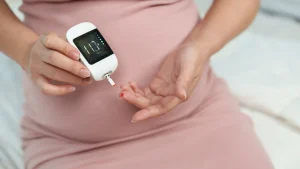 A pregnant woman confidently monitors her blood sugar as part of her high-risk pregnancy care for gestational diabetes.