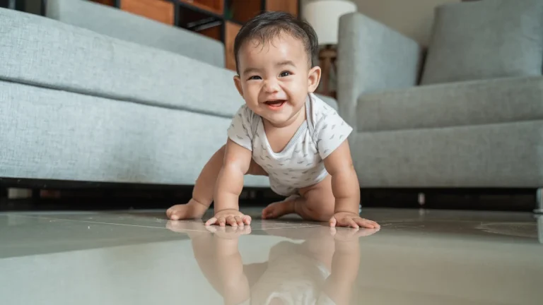 A healthy Indian baby at 6 months old sits up unsupported, a key baby milestone in child development.